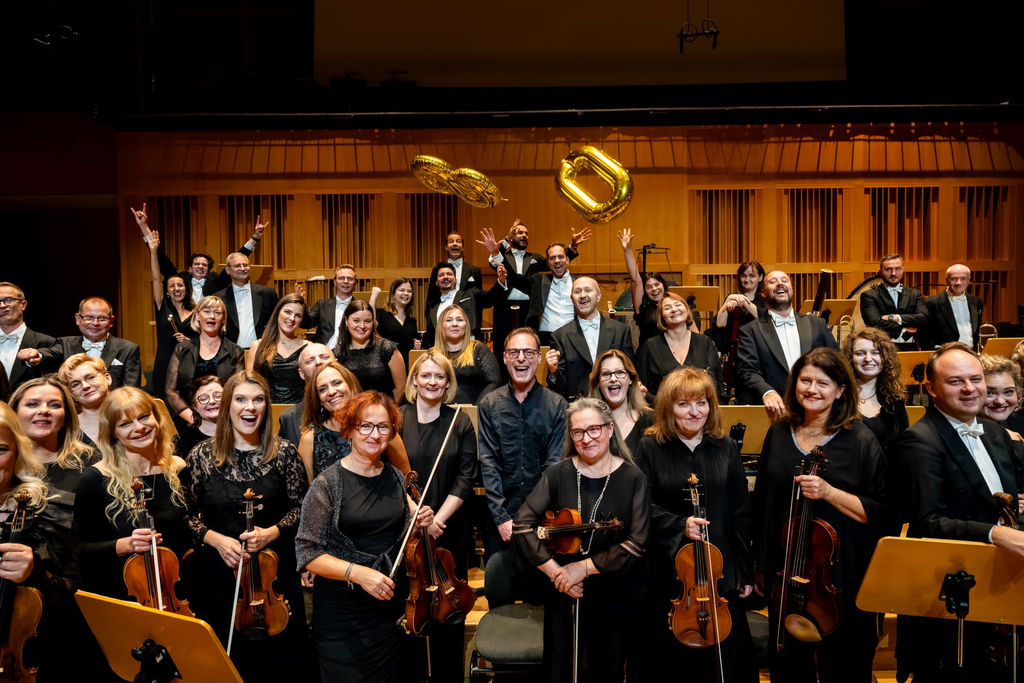 uśmiechnięci muzycy orkiestry pozują do zdjęcia